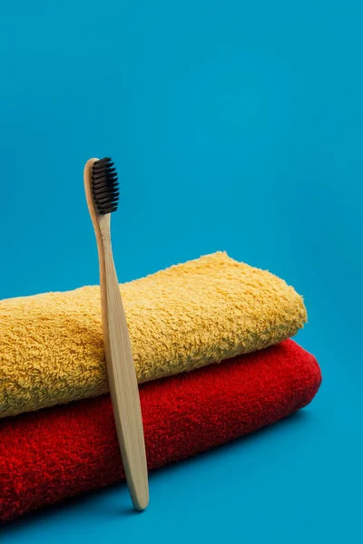 Szczoteczka Zębów Czerwonym Żółtym Ręcznikiem Niebieskim Tle — Zdjęcie stockowe