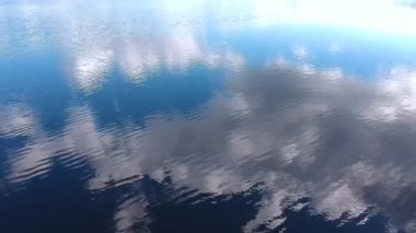 Göldeki sudaki bulutların yansımasının yüksekliğinden bak. Gölde dalgalar, yüksek bir yerden manzara