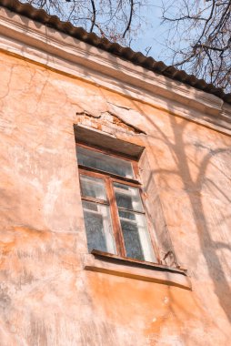 Terk edilmiş eski bir binada alçı soyulan bir pencere.