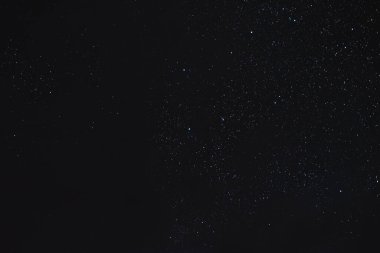 Gece gökyüzündeki yıldızlar bir yaz gecesinde bulutlar arasında