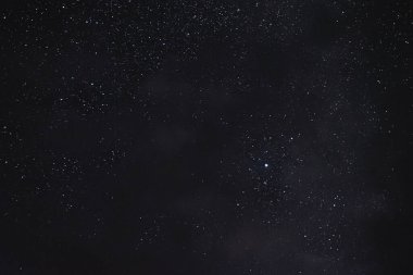 Gece gökyüzündeki yıldızlar bir yaz gecesinde bulutlar arasında