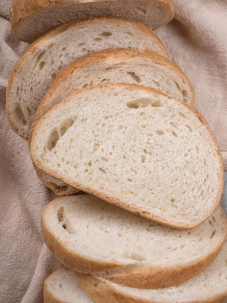灰色の背景に古い木のトレイに小麦粉と自家製の白黒小麦パンをスライス トップ表示 — ストック写真