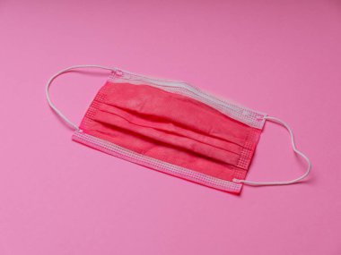 Pembe arka planda tıbbi koruyucu maske