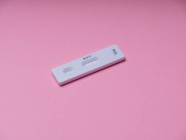 Novel Coronavirus, SARS-CoV-2 'nin IgM ve IgG antikorlarını tespit etmek için COVID-19 testi pozitif sonuç verdi. Coronavirus Express Test kartı. Pembe arka planda Covid-19 hızlı test. Coronavirus testi. maske