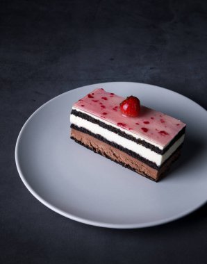 a piece of chocolate cake with strawberries on a dark table