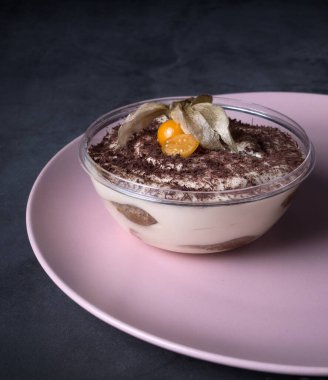 Tiramisu siyah arka planda cam bir kasede.