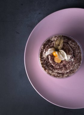 Granola ile ev yapımı kahvaltı, siyah arka planda yoğurt. Tiramisu siyah arka planda cam bir kasede.