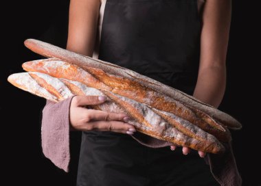 Fırıncı siyah üzerine izole bir ekmek sepeti tutar.