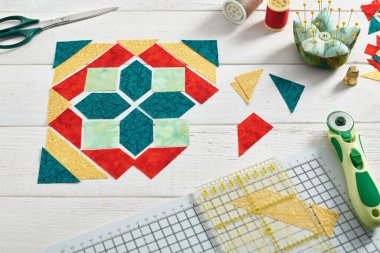 Yama bloğu şeklinde serilmiş kumaş parçaları, dikiş ve yorgan aksesuarları..