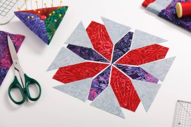 Yama bloğu şeklinde serilmiş kumaş parçaları, dikiş ve yorgan aksesuarları..