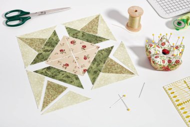 Yama bloğu şeklinde serilmiş kumaş parçaları, dikiş ve yorgan aksesuarları..