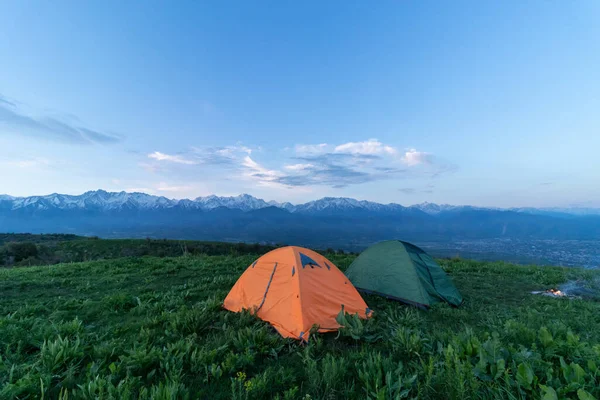 Dva Stany Stojí Vrcholu Zeleného Kopce Pozadí Vrcholky Hor Mraky — Stock fotografie