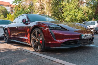 Almaty, Kazakistan - 21 Temmuz 2025: Şehrin otoparkında bir bordo Porsche Taycan 4S. Elektrikli spor araba.
