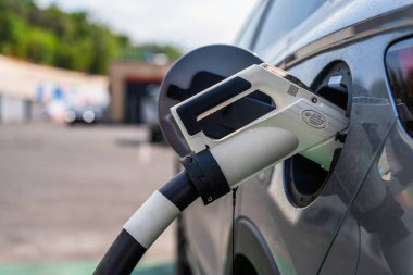 Almaty, Kazakistan - 30 Temmuz 2025: Şarj silahı elektrikli arabaya yerleştirildi. Yakıt istasyonu