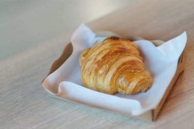 Kağıt tabakta ev yapımı tereyağı kruvasanı.