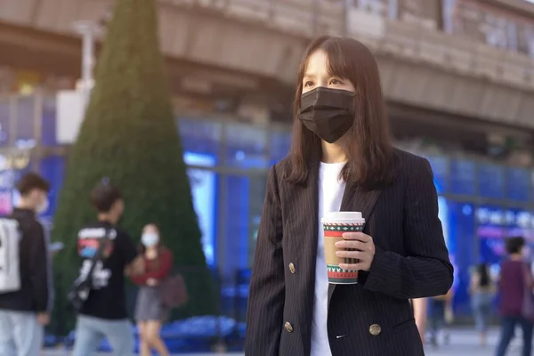 アジアオフィスの女性とフェイスマスク付きコーヒーカップ — ストック写真
