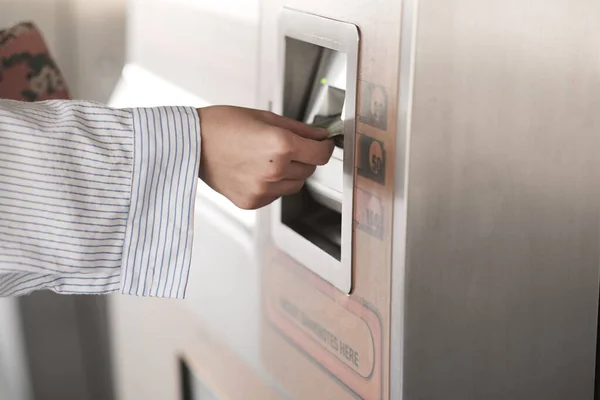 Women Purchasing an train ticket from a ticket machine