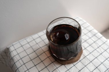 Tahta tabakta bir bardak buzlu siyah kahve.