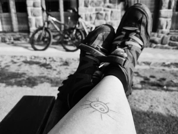 sun drawn on woman\'s leg with bicycles on the background