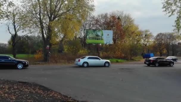 Розкішний автомобіль на дорозі на фоні поля — стокове відео