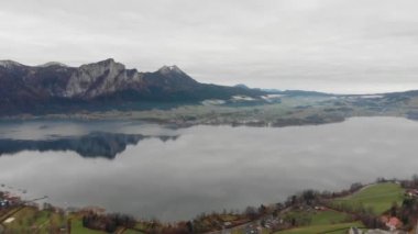 Avusturya köyünün manzarası ve kolay kar pelerinli dağlar. 4K video.