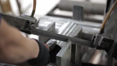 Metal atölyesindeki öğütme makinesinin yardımıyla çelik borunun bir kısmına kaynak yapılmış dikiş.