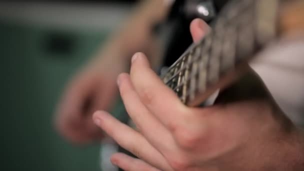 Tocando la guitarra eléctrica. Tiro macro de las cuerdas y dedos de la guitarra. Estudio negro — Vídeo de stock