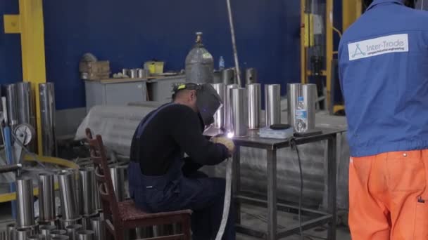 Trabajador de la construcción en el sitio de soldadura de tubos de metal con casco azul especial, cámara lenta — Vídeos de Stock