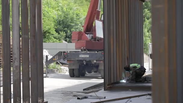 Anleggsarbeider på byggeplassen sveisemetallrør med spesiell blå hjelm, langsom bevegelse – stockvideo