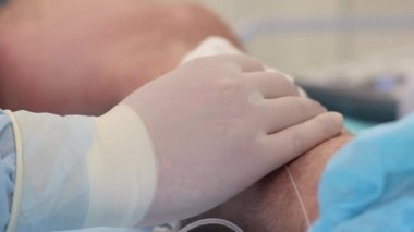 Bir hemşire hastanede bir hastaya damar yolu açmaya hazırlanıyor.