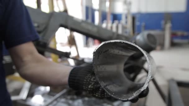 Sveiset søm på en del av et stålrør ved hjelp av en slipemaskin i metallverkstedet – stockvideo