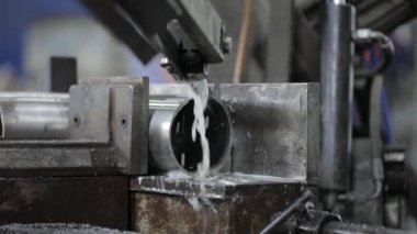 Metal atölyesindeki öğütme makinesinin yardımıyla çelik borunun bir kısmına kaynak yapılmış dikiş.