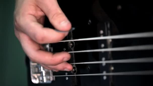 Tocando la guitarra eléctrica. Tiro macro de las cuerdas y dedos de la guitarra. Estudio negro — Vídeo de stock