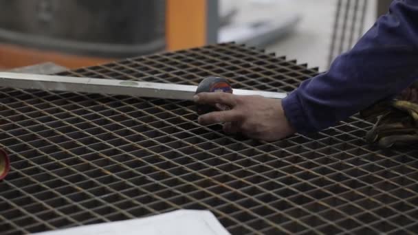 Baard monteur snijdt metaal met een haakse slijper in een tankstation — Stockvideo