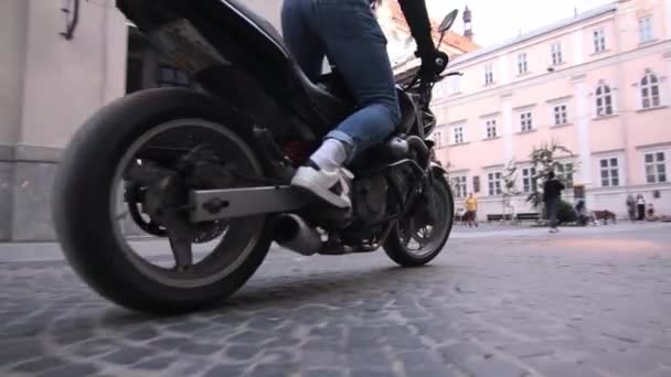 Nuori valkoihoinen moottoripyöräilijä ajamassa moottoripyörällään kaupungissa, hidasliikkeinen, nosturi laukaus, hidasliikkeinen — kuvapankkivideo