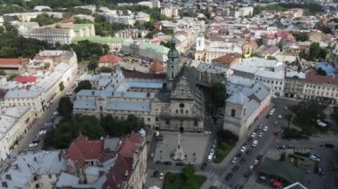 Ukrayna 'daki sisli Lviv şehrinin üzerinde uçuyor. Ukrayna 'nın eski Lviv kasabasındaki Pazar Meydanı mimarisinin manzaralı yaz manzarası. Belediye binası ve Pazar Meydanı kuş bakışı. Yaz sisli