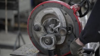 Metal atölyesindeki öğütme makinesinin yardımıyla çelik borunun bir kısmına kaynak yapılmış dikiş.
