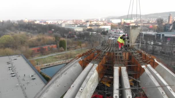 Opptak fra luftfartøy av arbeidere i en konstruksjon, struktur i prosessen som skal bygges – stockvideo