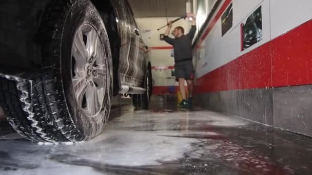 Lavado de coches: el hombre sostiene la microfibra en la mano y lava el automóvil — Vídeos de Stock