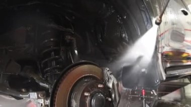 Erkek işçi arabayı yıkar. Yüksek Basınçlı Suyu Kullanarak Araba Temizleme.