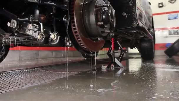 Mannelijke werknemer wast de auto. Reinigingsauto met behulp van hogedrukwater. — Stockvideo