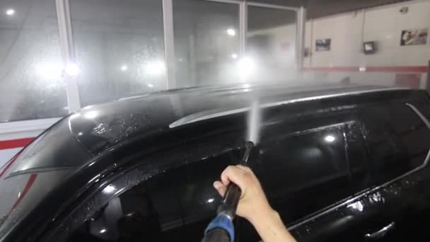Bilvask - mannen holder mikrofibrene i hånden og vasker bilen – stockvideo