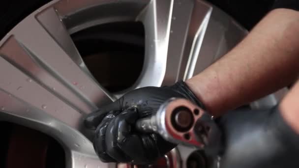 Mannlig arbeider vasker bilen. Rengjøringsbil ved hjelp av høytrykksvann. – stockvideo