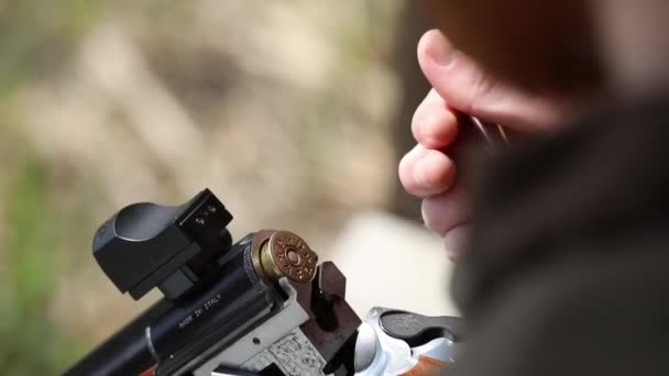 Чоловік в камуфляжі готує зброю для стрільби . — стокове відео