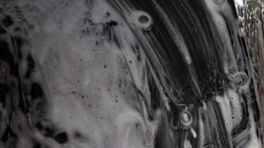 Erkek işçi arabayı yıkar. Yüksek Basınçlı Suyu Kullanarak Araba Temizleme.