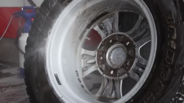 Mannelijke werknemer wast de auto. Reinigingsauto met behulp van hogedrukwater. — Stockvideo