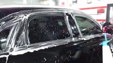 El yıkaması, özel bir hortumla arabasını yıkayan bir adam. El ile taşınabilir araba yıkama. Ayrıntılı ve nazik araba bakımı