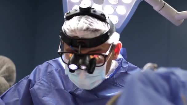 Kirurg-lege som har på seg spesiell lampebelysning ved hjelp av elektrisk hjertekirurgi-intervensjon tett inntil, åpen strengkirurgi - minimalt invasiv kirurgi – stockvideo