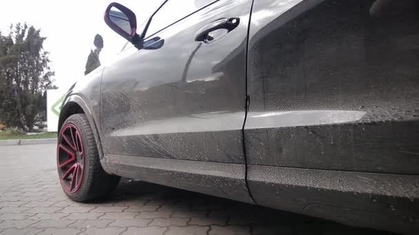 Manual car wash. A man washes his sedan from a special hose. Manual portable car wash. Detailed and gentle car care — Stock Video