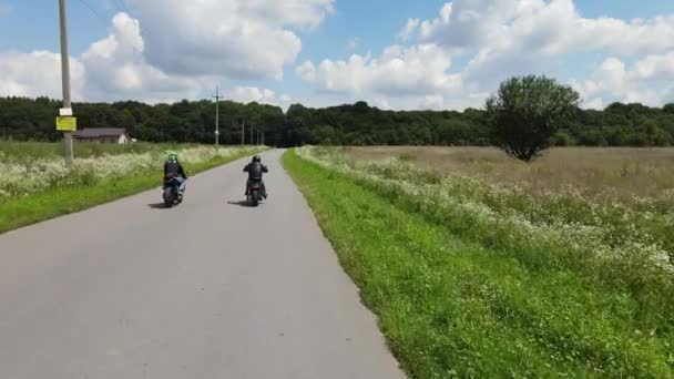Moottoripyöräilijä ajaa moottoripyörällä. Ajaa maalaistiellä Seikkailuja kissan pyörä luonnossa. — kuvapankkivideo